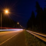 Headlights seen along a road at night.