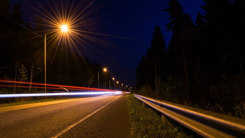 Headlights seen along a road at night.