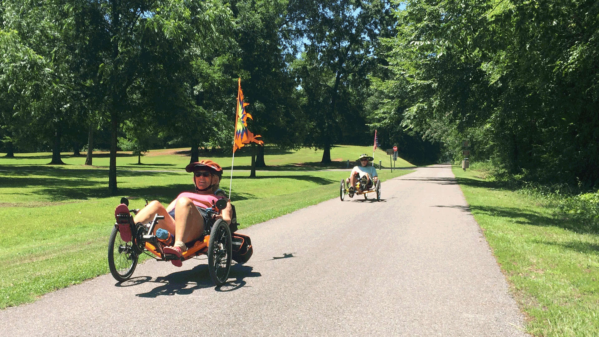 tow people on recumbent bikes pedal along a path in an alabama state park