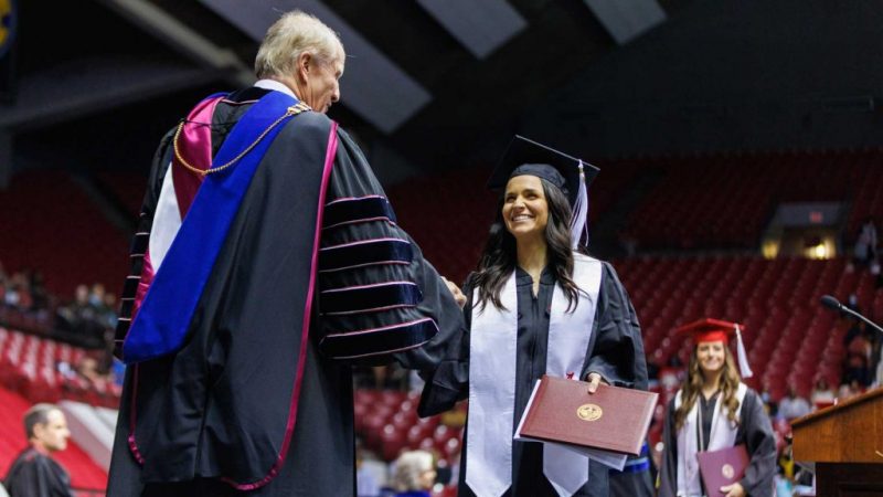 A graduate shakes hands with UA president Dr. Stuart Bell.