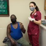 A nurse and patient giving a thumbs up