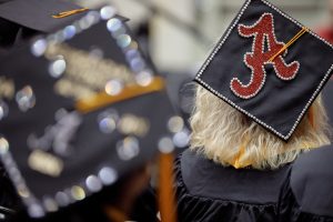The script A of The University of Alabama is on top of a mortar board at graduation.