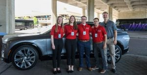 A group photo in front of an SUV.