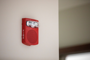A fire alarm on a wall of a building.