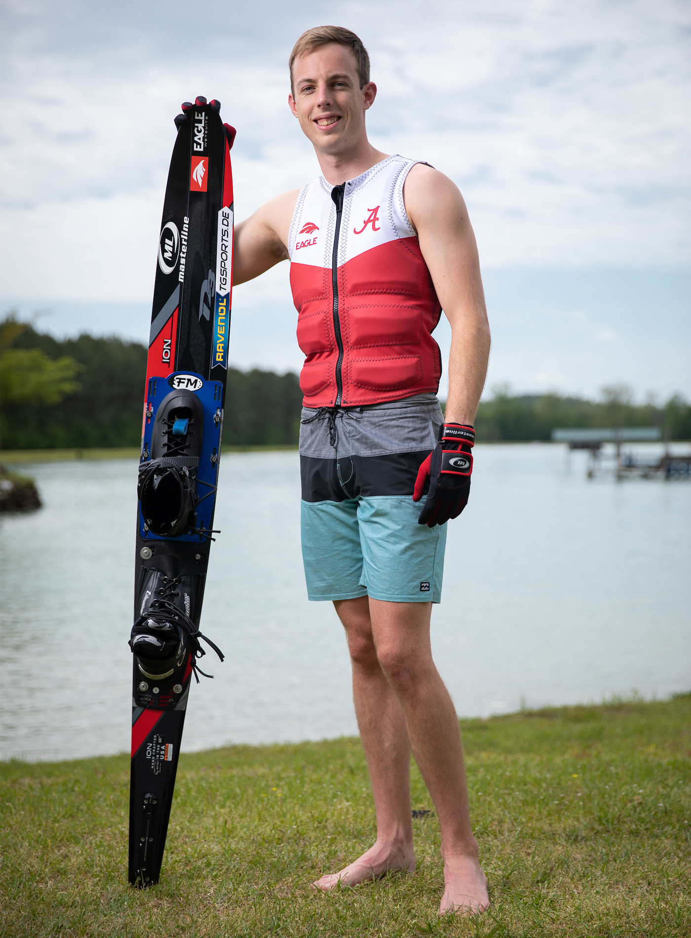 Sean Hunter holding his water skis in front of a lake