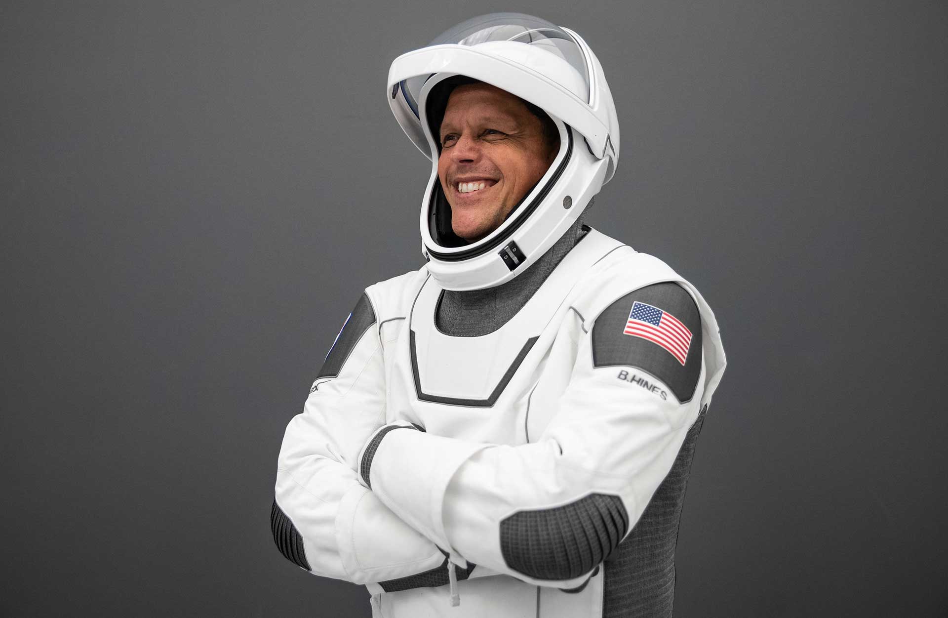 A man smiles in a spacesuit