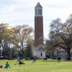 Students sit on the Quad at The University of Alabama on a sunny day.