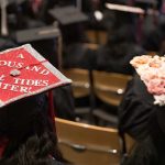 Two mortar board caps are seen. One is bright red and the other is light pink.