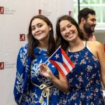 Two female students pose with a Cuban flag.