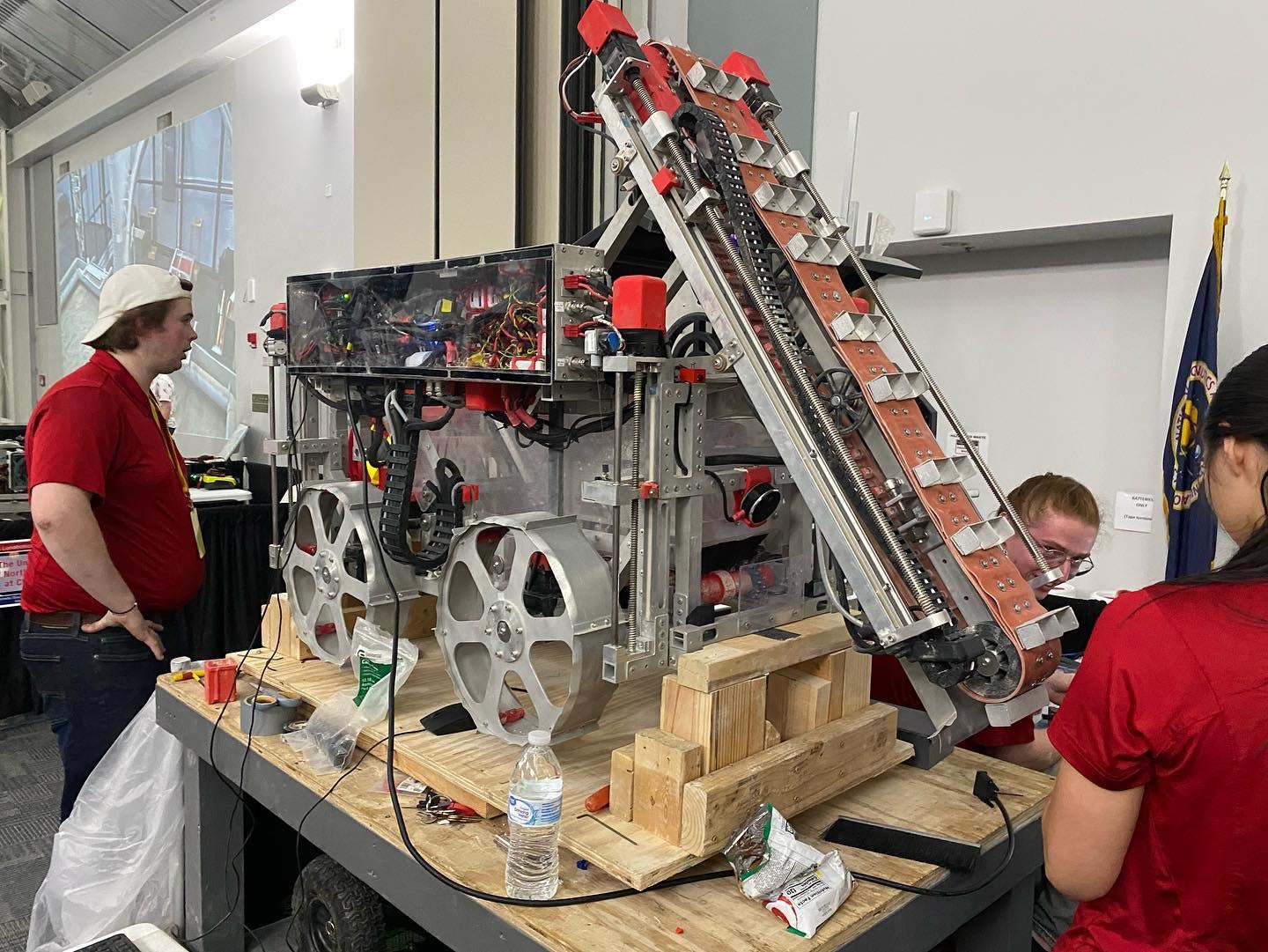 A rover-type robot on a high table with people around it working on it.