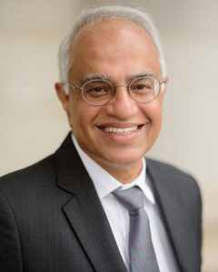 A professional headshot of a UA professor in suit and tie.