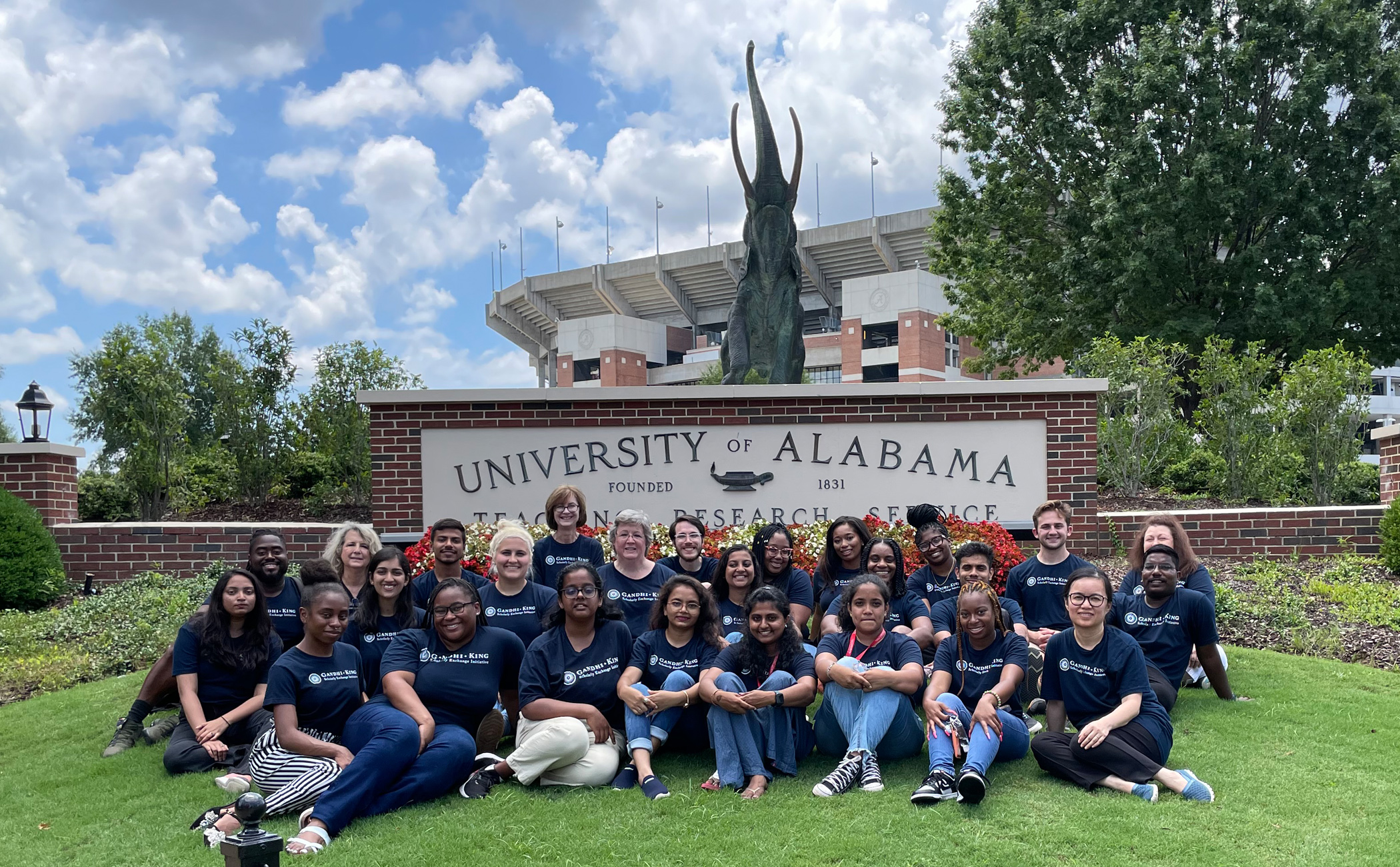 The Gandhi King student and faculty participants in front of a University of Alabama sign