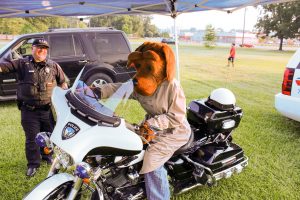 A person dressed in a dog costume sits on a motorcycle.