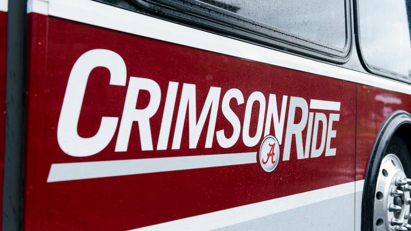 The logo of Crimson Ride on the side of a bus at The University of Alabama.