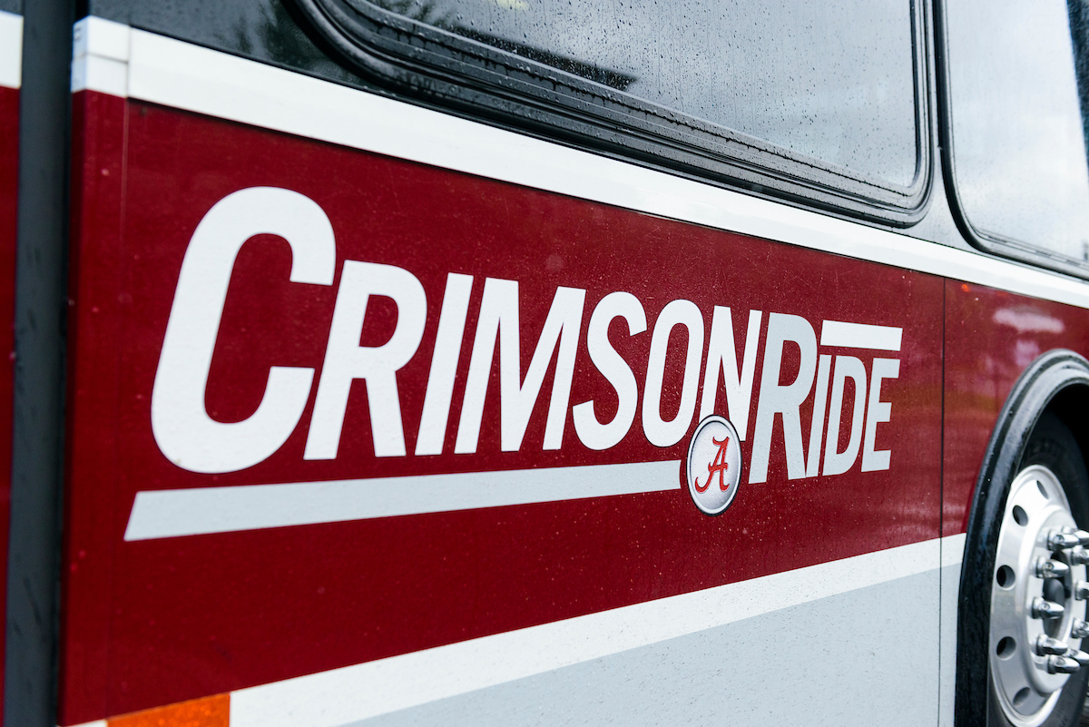 The logo of Crimson Ride on the side of a bus at The University of Alabama.