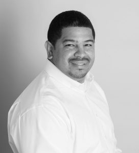 A black and white photo of a man in a white shirt.