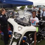A girl sits on a police motorcycle.