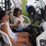 Two girls sit in a UAPD off-road vehicle.