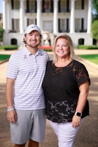A man and woman stand in front of the president's mansion.