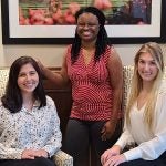 Three women pose for photo in an office at The University of Alabama.