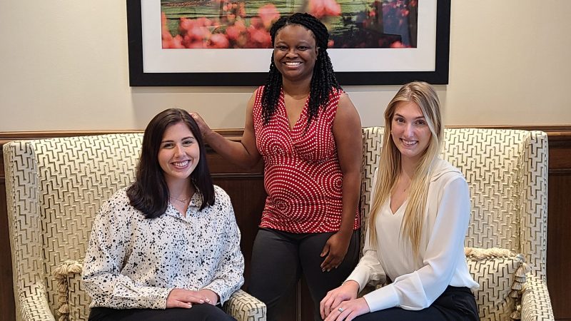 Three women pose for photo in an office at The University of Alabama.
