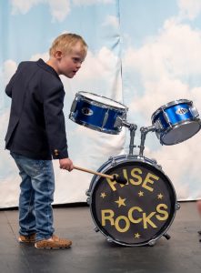 A Rise student playing with a drum set