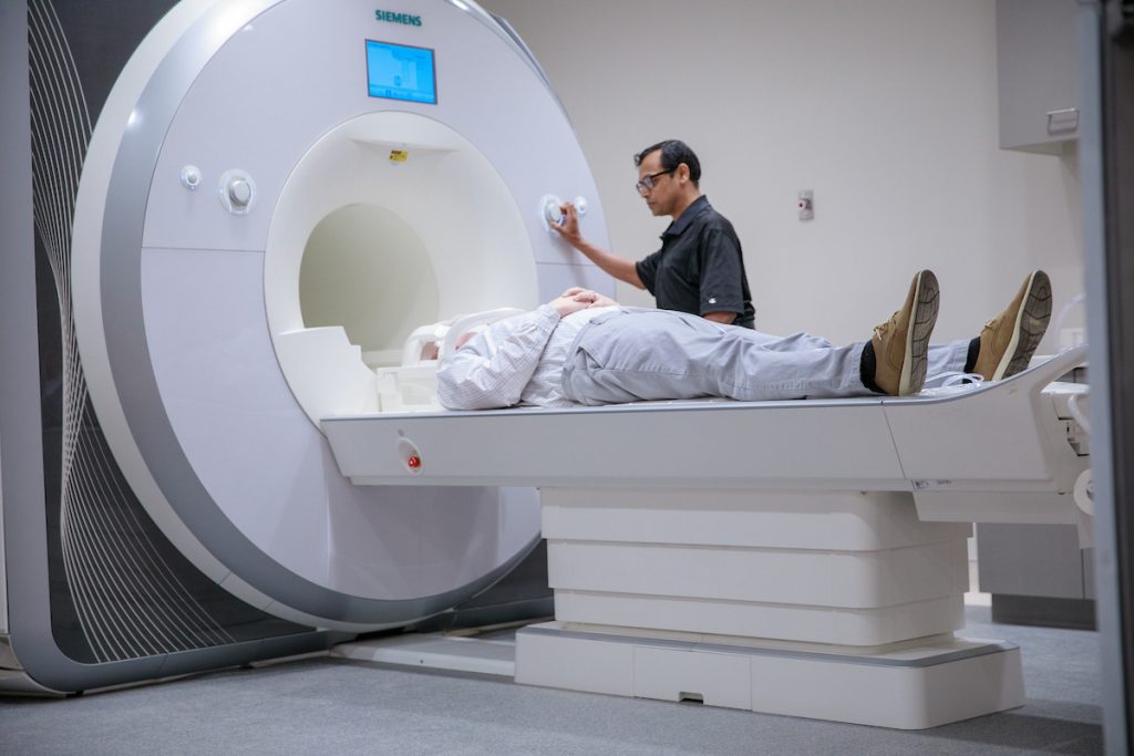 A patient lies flat on an MRI scanner.