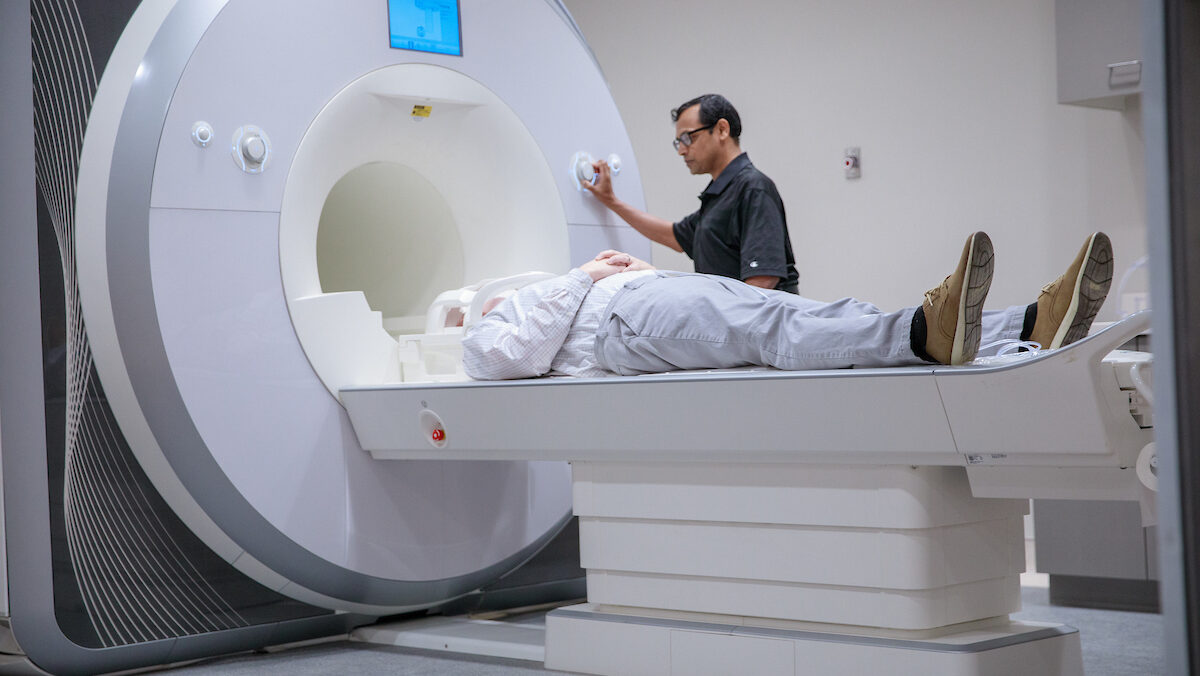 A patient lies flat on an MRI scanner.
