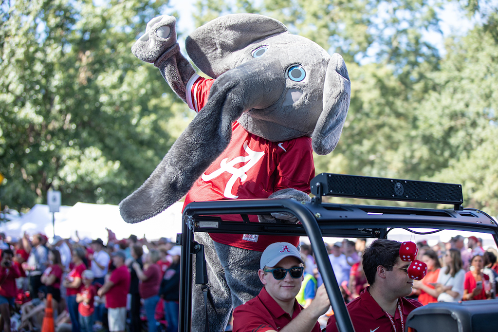 Big Al waves to the crowd as he rides on the back of a truck in a homecoming parade.