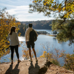 two students standing on a rock overlooking a lake