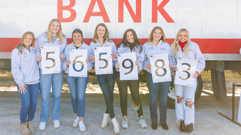 Students hold a sign saying 565,983.