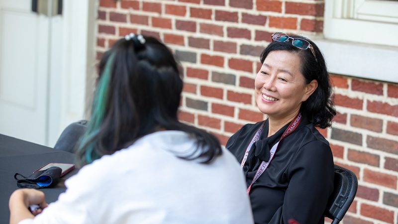 Dr. Lee smiles while talking to a student
