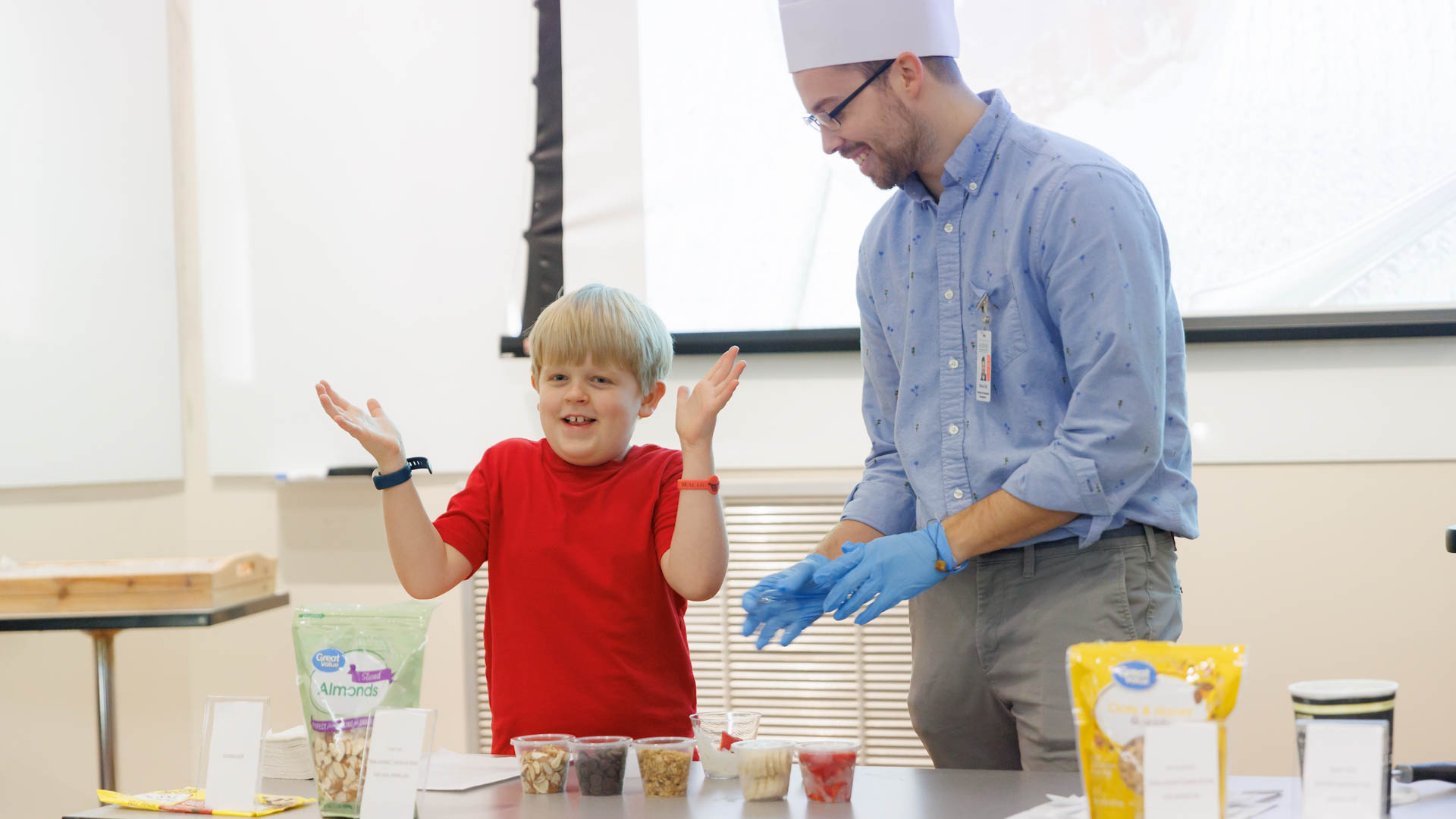 a young boy helps a chef make a snack