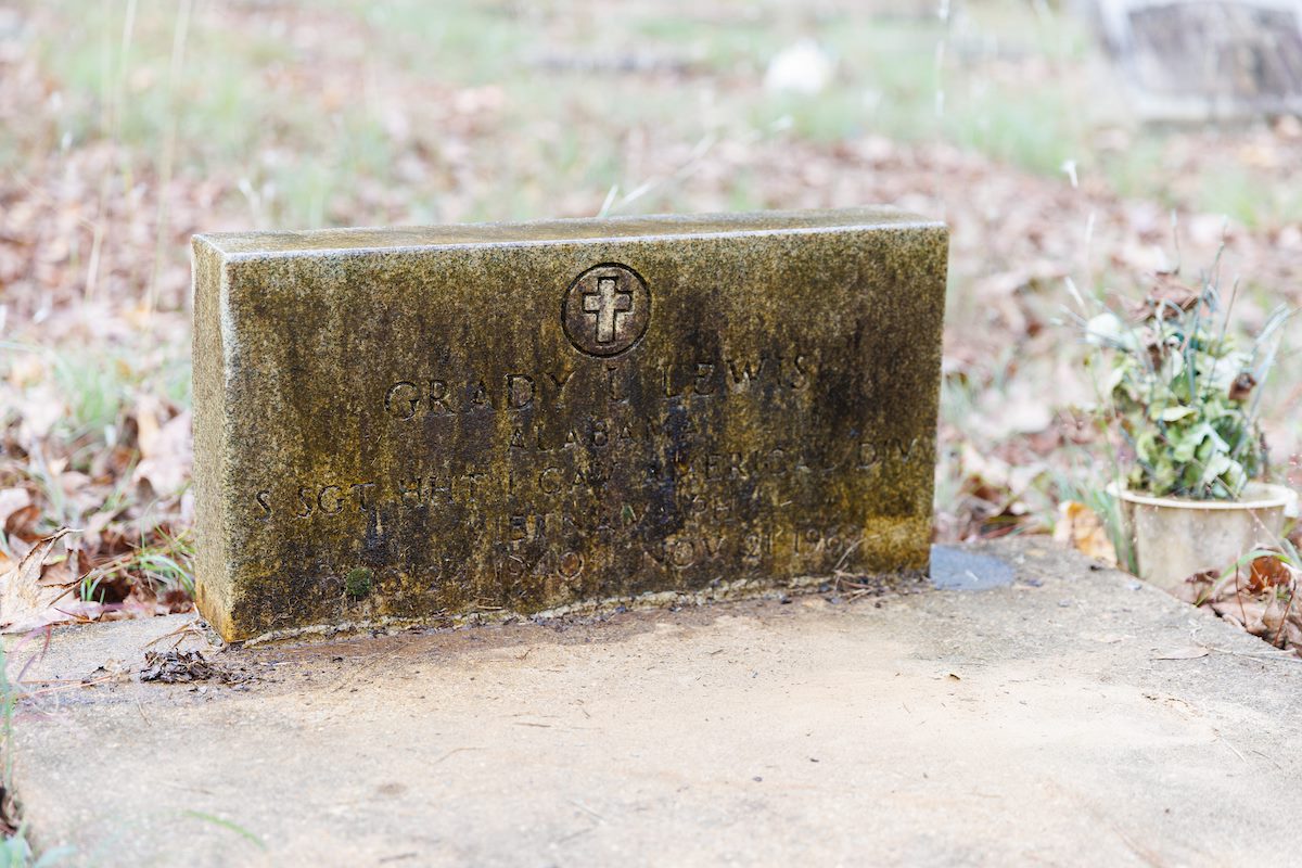 military headstone covered in dirt