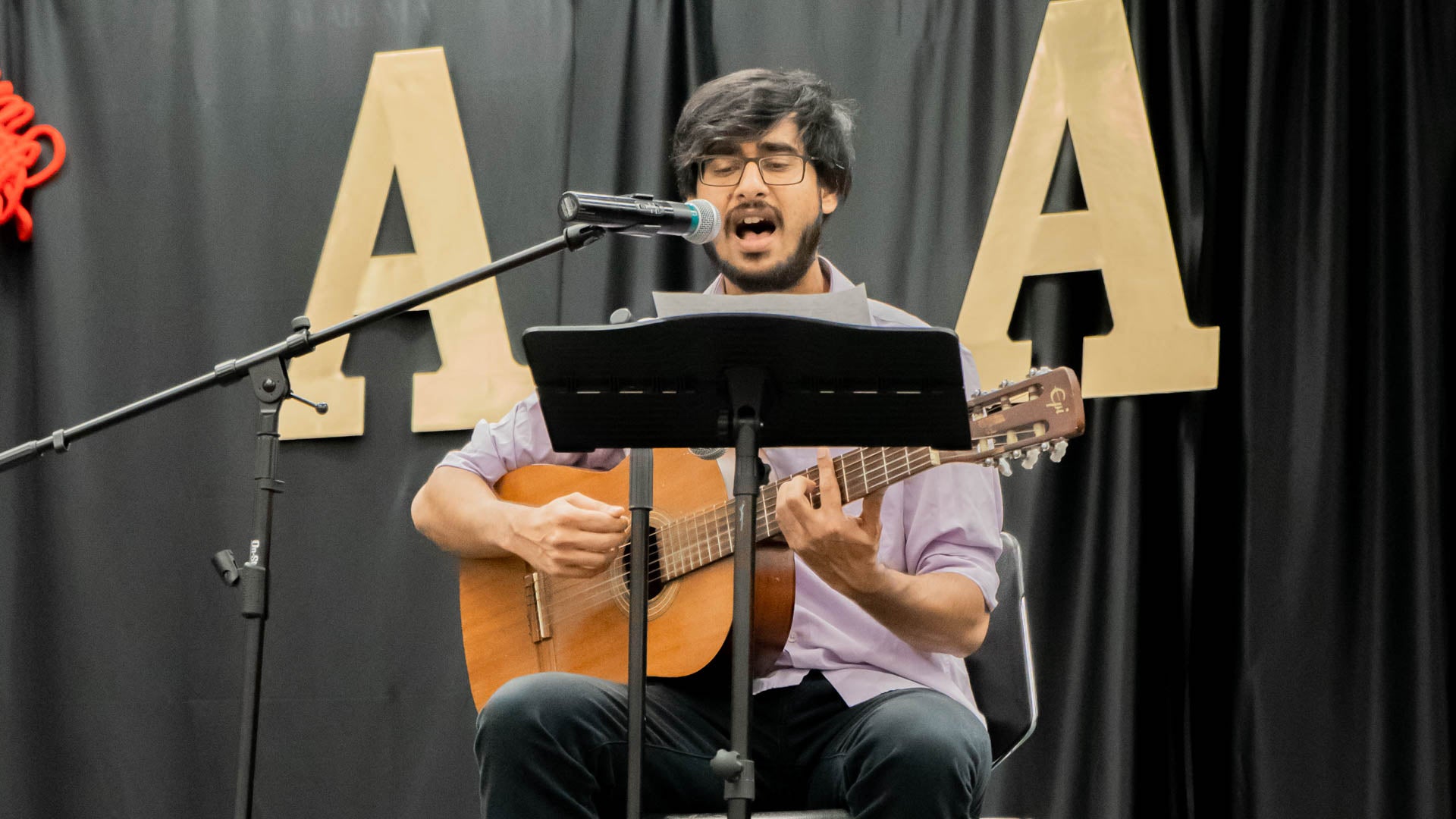 a young man plays guitar while singing