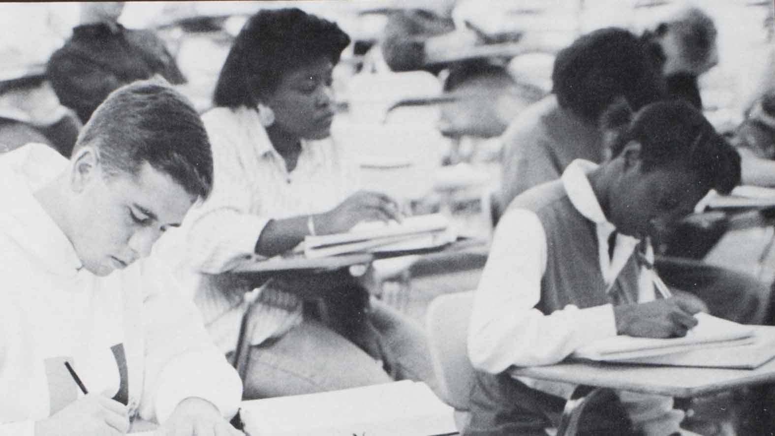 African American female student taking notes in class.