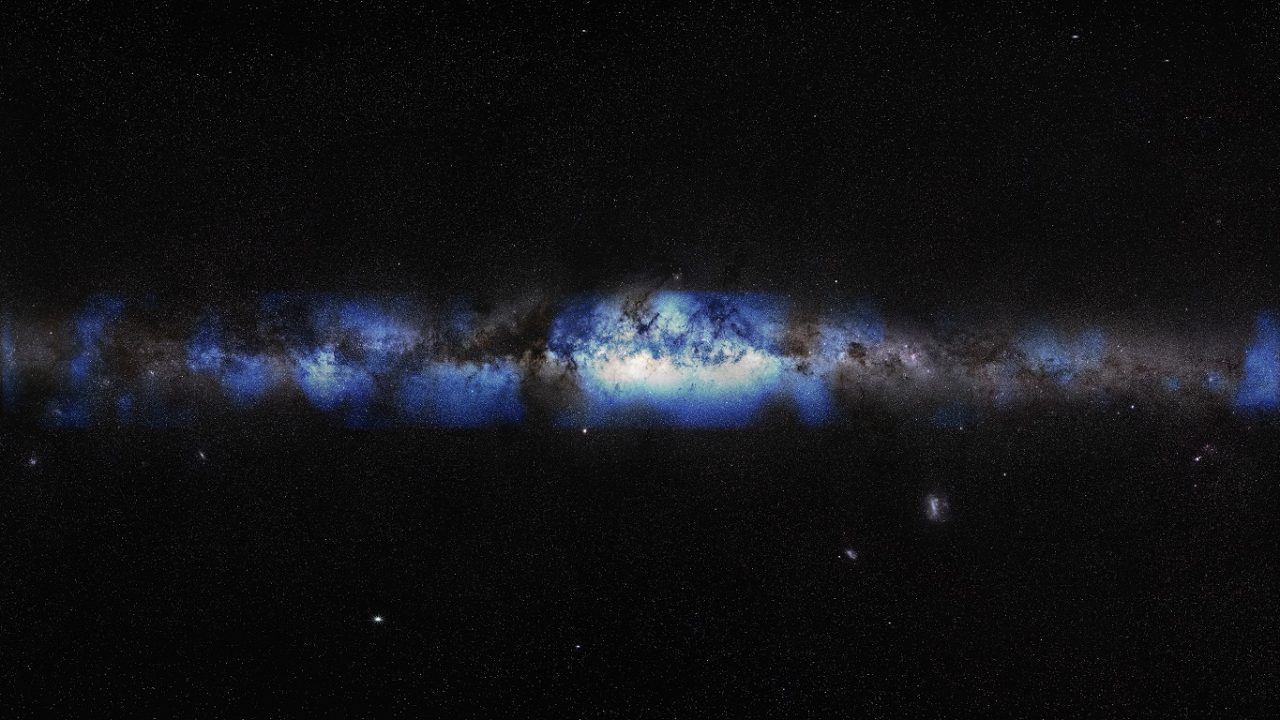 A blue-tinted Milky War galaxy in a line against the blackness of space.