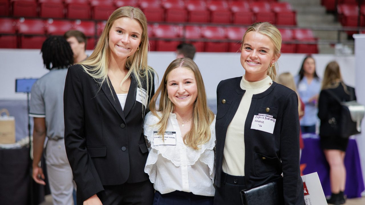 three young women dressed in professional attire at the career fair