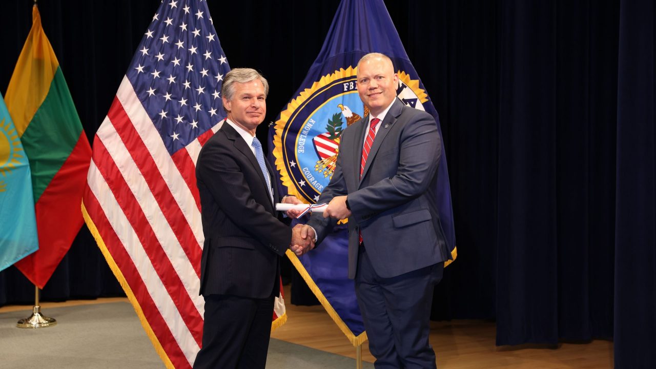 FBI Director Christopher Wray presents UAPD Captain Chad Stephens with a diploma.