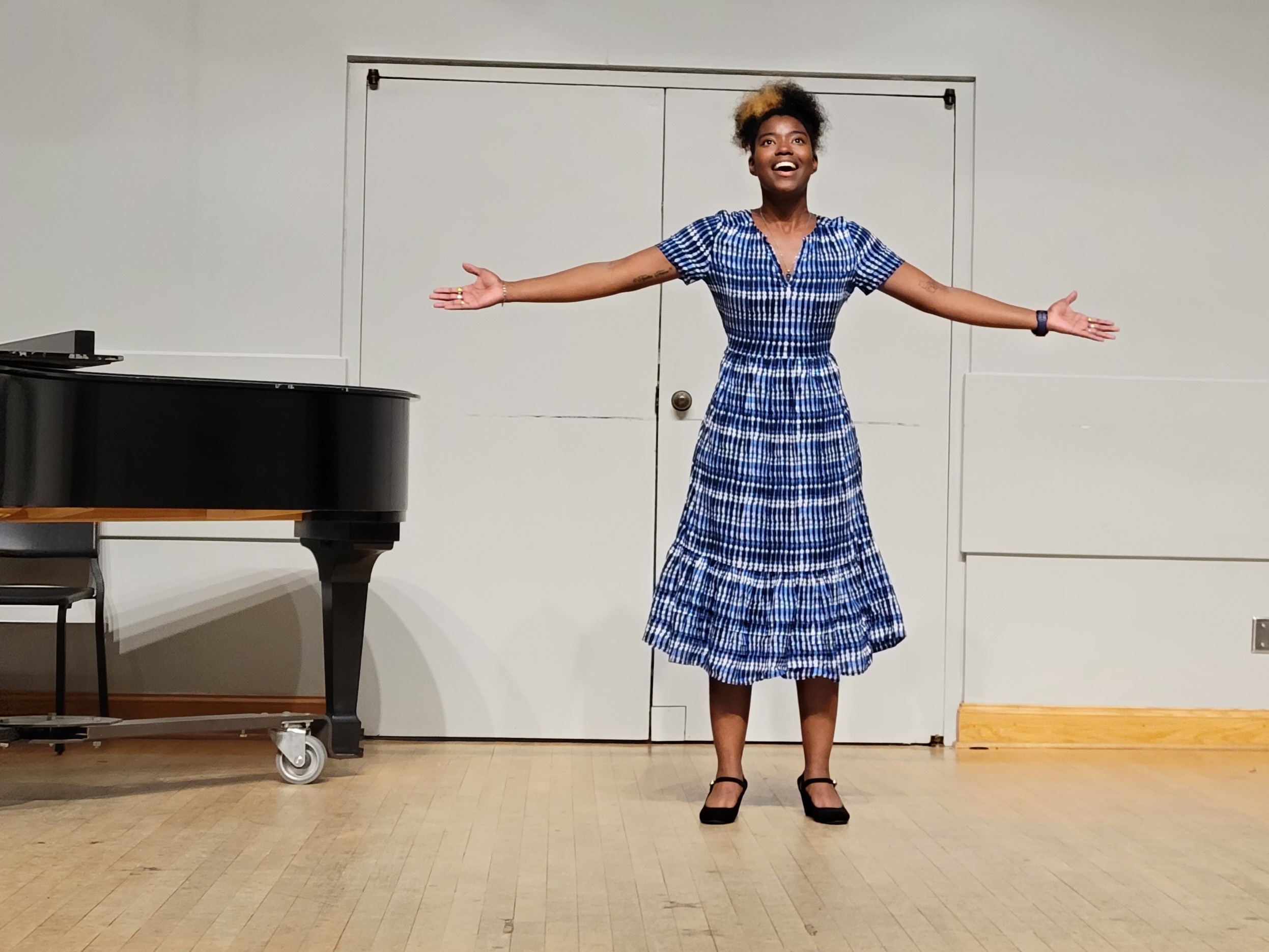 Teandra Jackson sings onstage in a blue dress.
