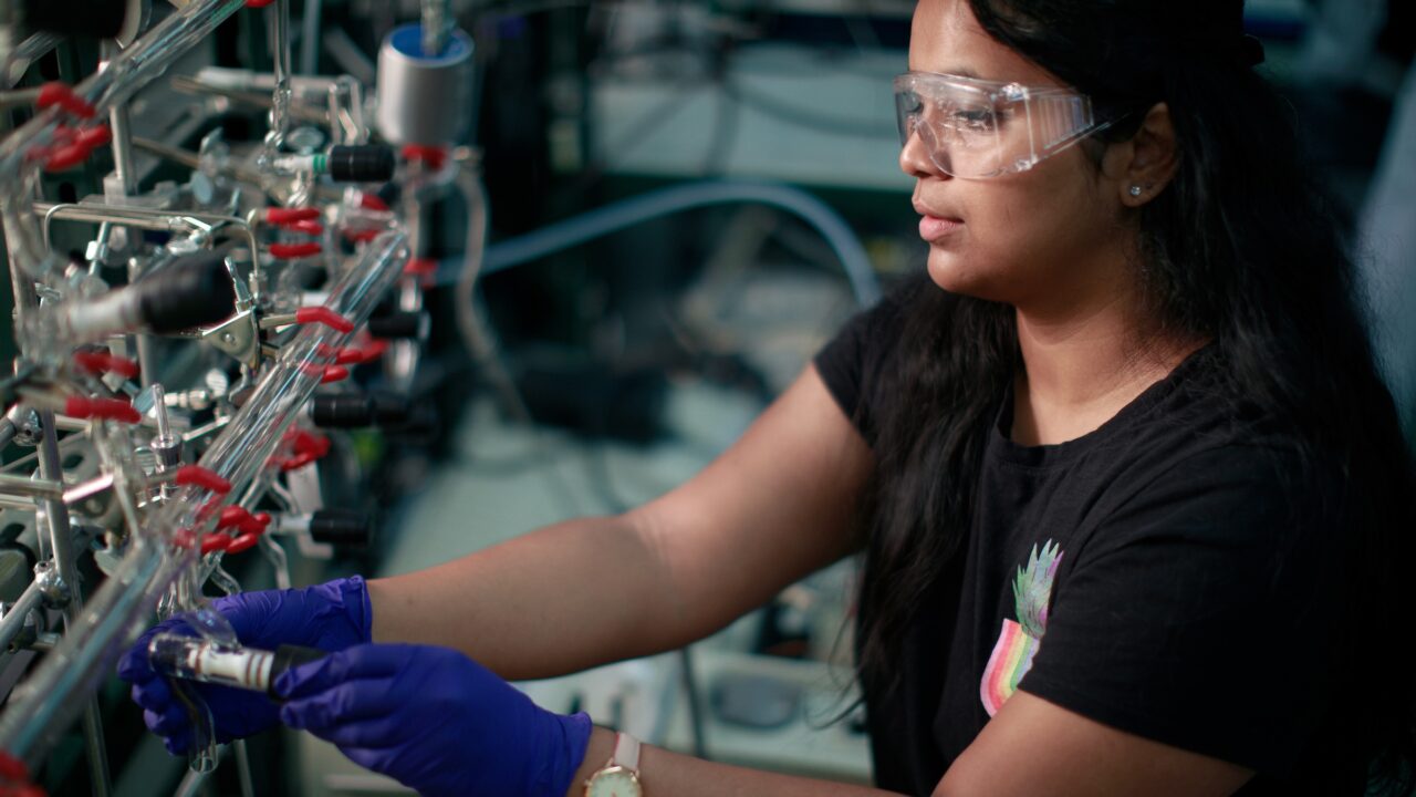 A woman works a glass vacuum manifold as part of research in a science laboratory at The University of Alabama.