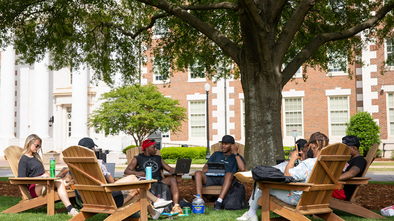 students sit in chairs on the Quad
