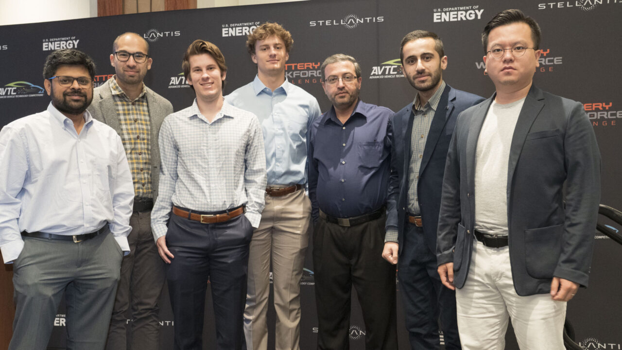 A group of faculty and students from The University of Alabama pose for a photo in front of a backdrop for the Battery Workforce Challenge.