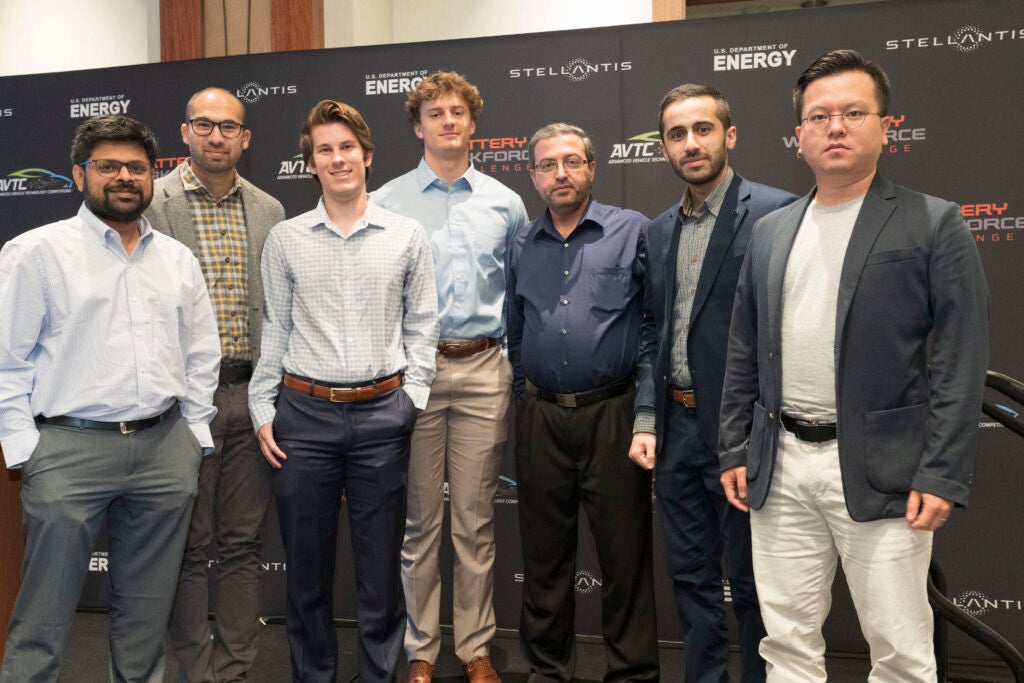 A group of faculty and students from The University of Alabama pose for a photo in front of a backdrop for the Battery Workforce Challenge.