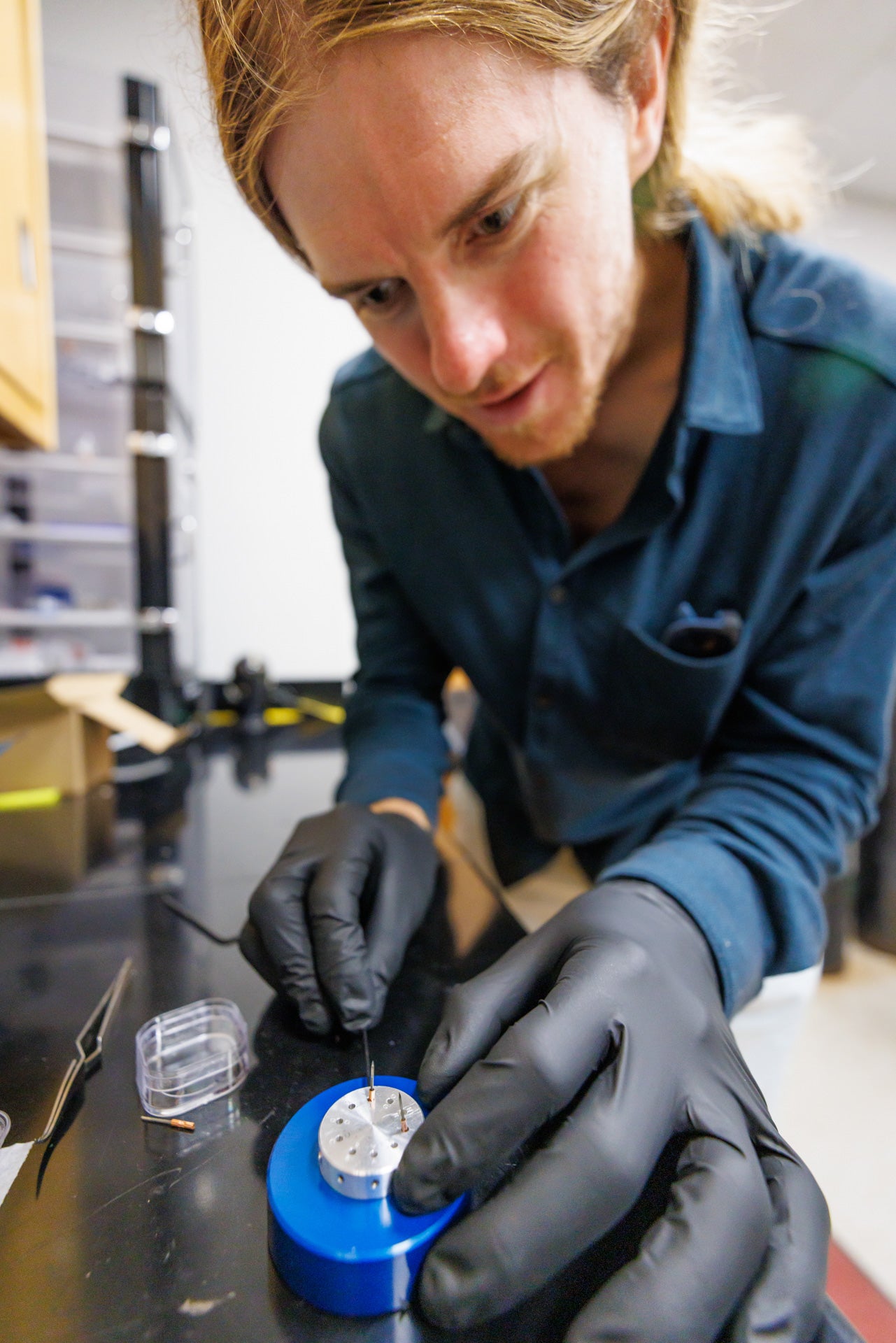 Close up of researcher wearing gloves working on lab equipment