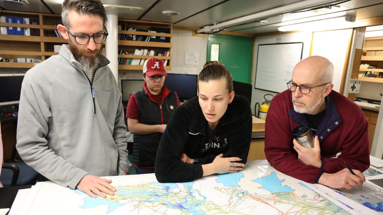 Members of the research team look at a large map