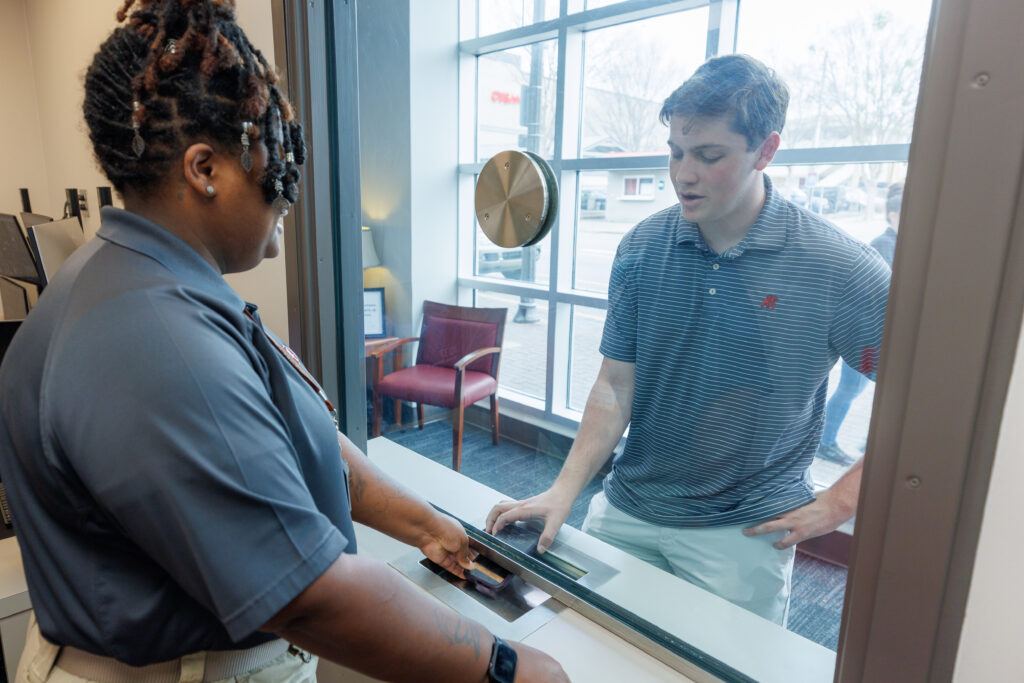 A student hands a cell phone that he found to a Security Resources Assistant in the new University Police precinct.