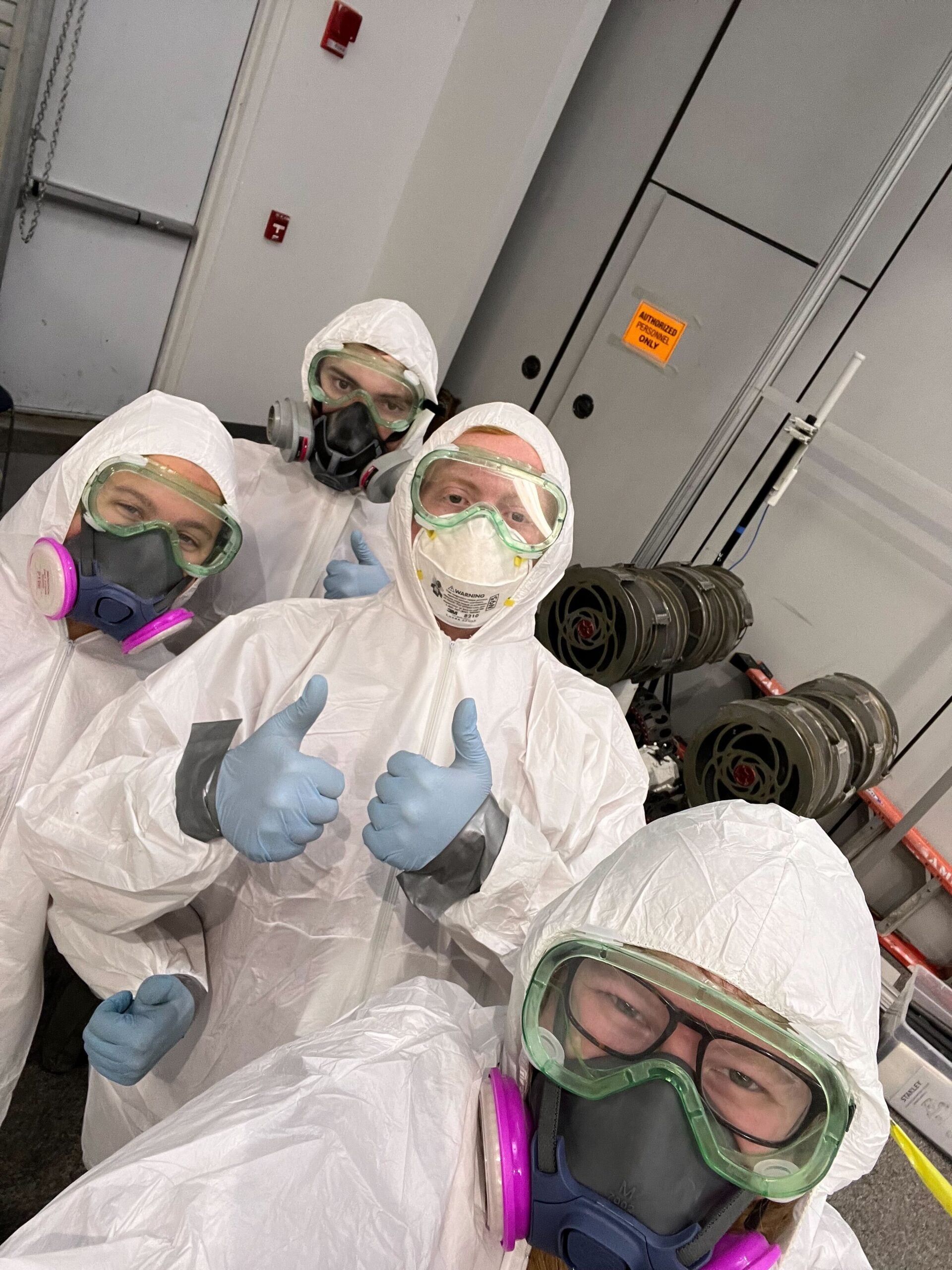 Four Astrobotics team members in protective clothing and face masks needed for the simulated lunar environment. 