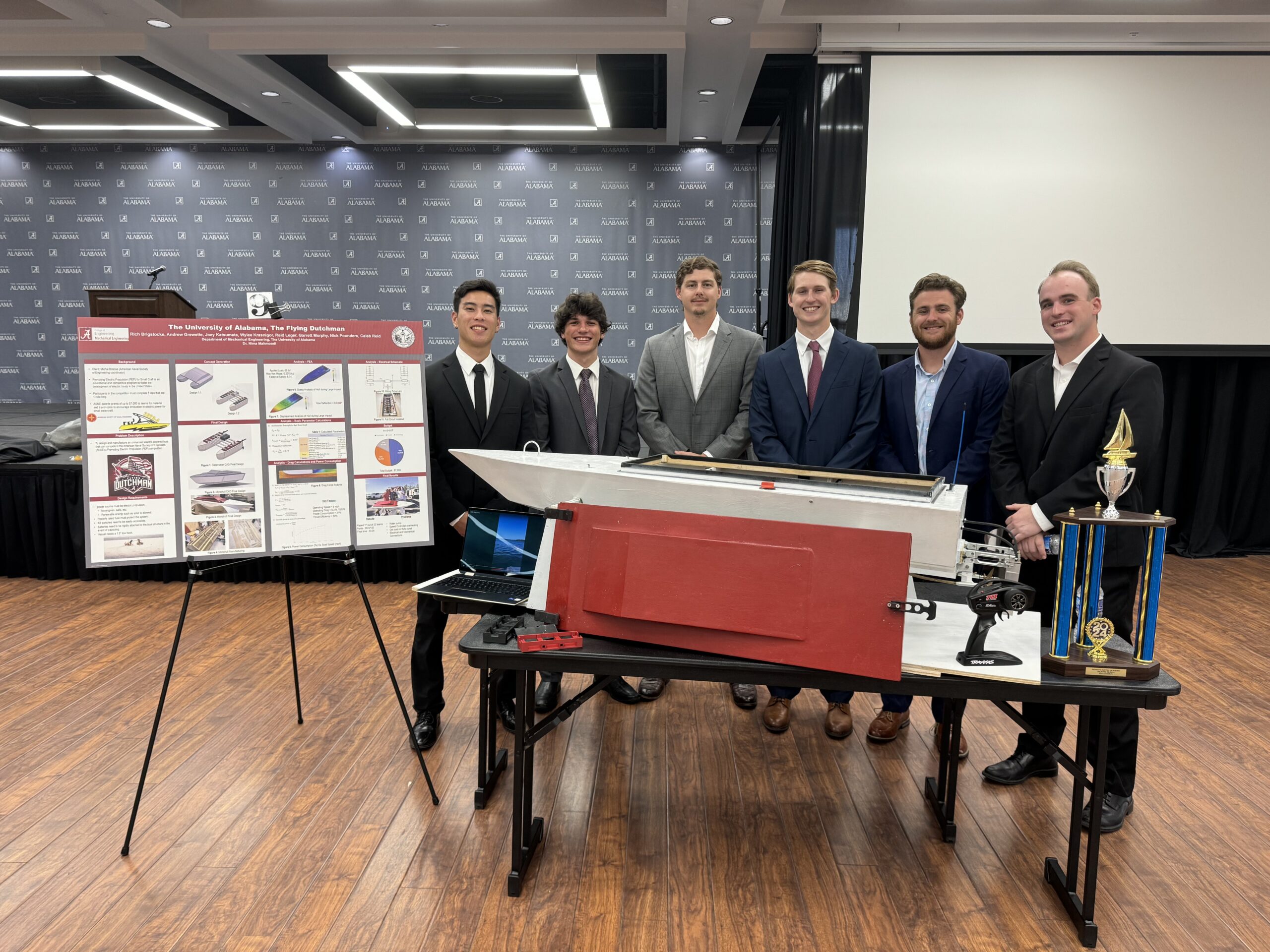 Six UA engineering students stand with their senior design project at the senior design poster competition. 
