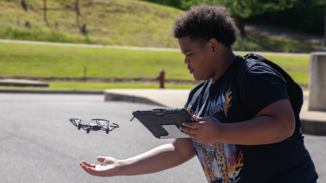 Student plays with small drone